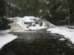 Dark waters leading up to the icy falls