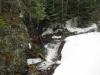White flakes falling above the busy little creek
