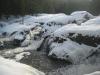 Flowing falls around the snowy heaps