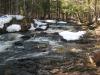 Small upstream drops between snowy rocks