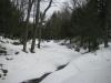 Mounds of snow hanging over the creek