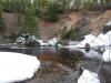 Snow piled up below the tall sandy bank