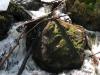Water cascading around the large boulder