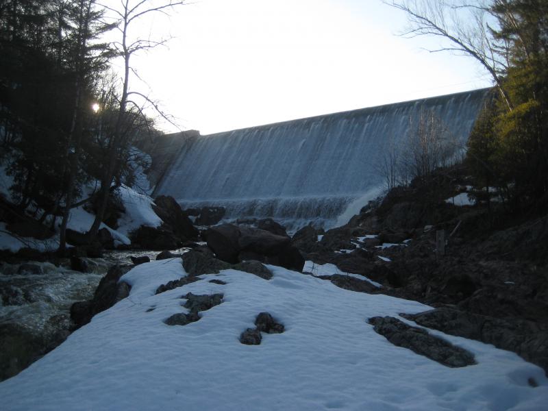 Setting sun over the overflowing dam