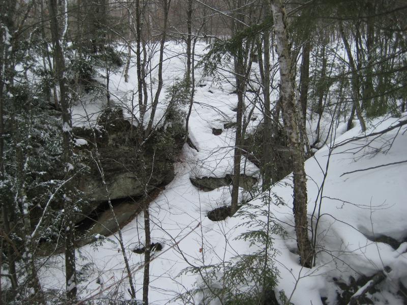 Snow spilling into the creek gorge