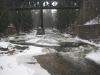 Falling snow flakes near the old bridge