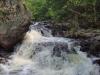 Cascades flowing around a boulder